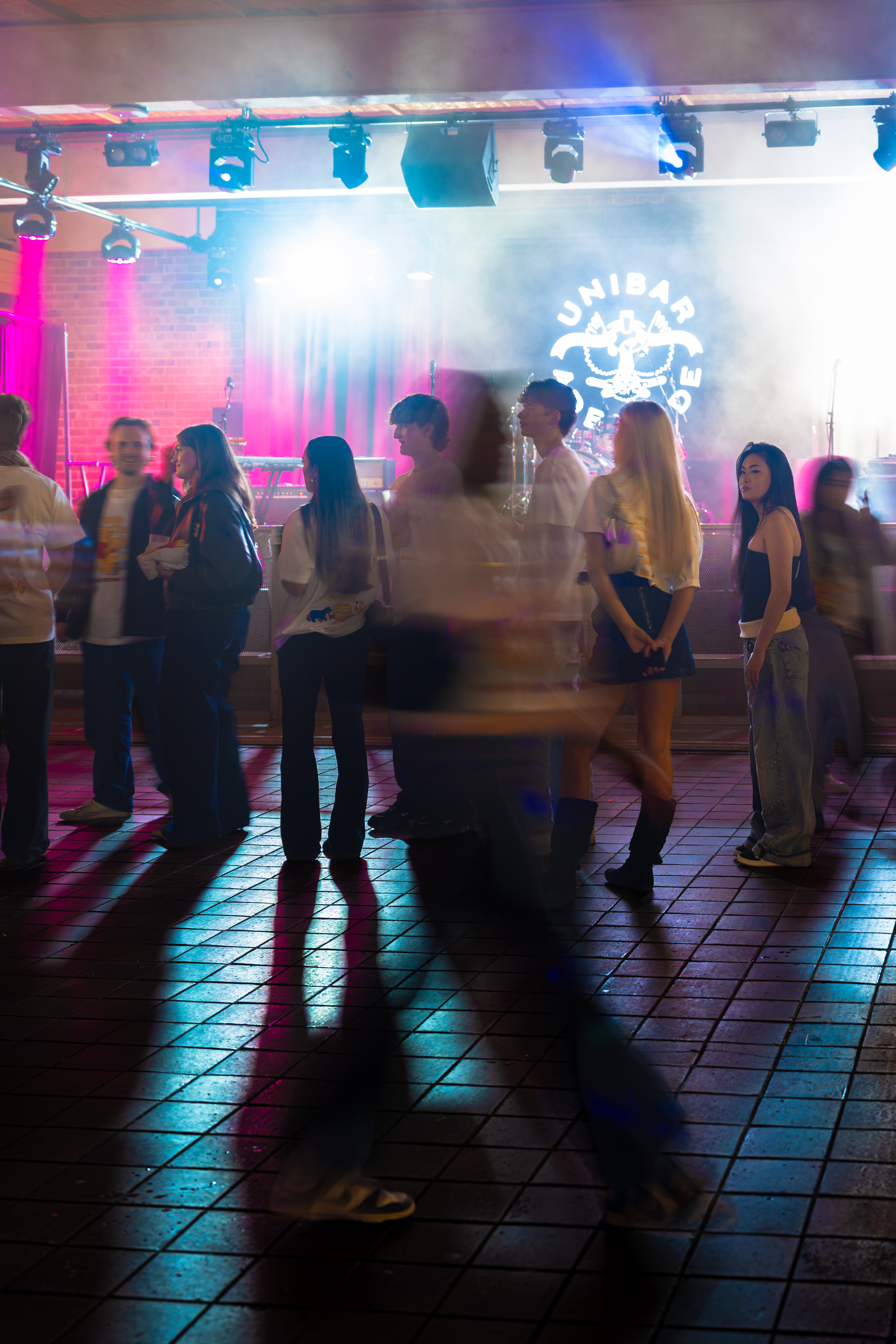 Guests on the dance floor under colourful stage lights