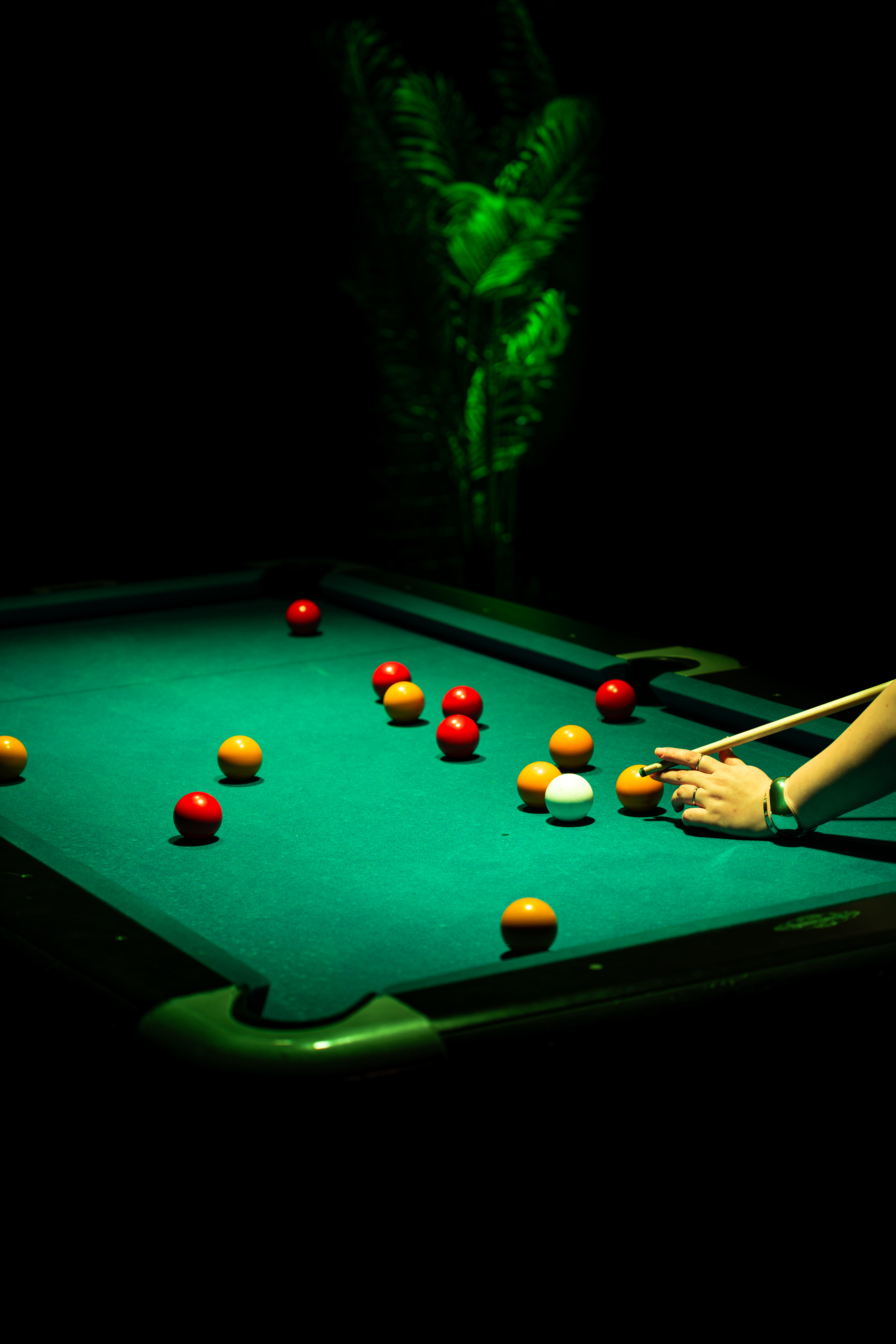 A game of pool under green lighting